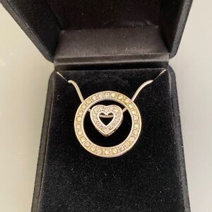 Silver tone necklace on 18” adjustable solid silver tone chain. Clear stones.